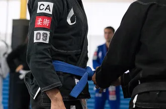 A BJJ practitoner receiving thier blue belt